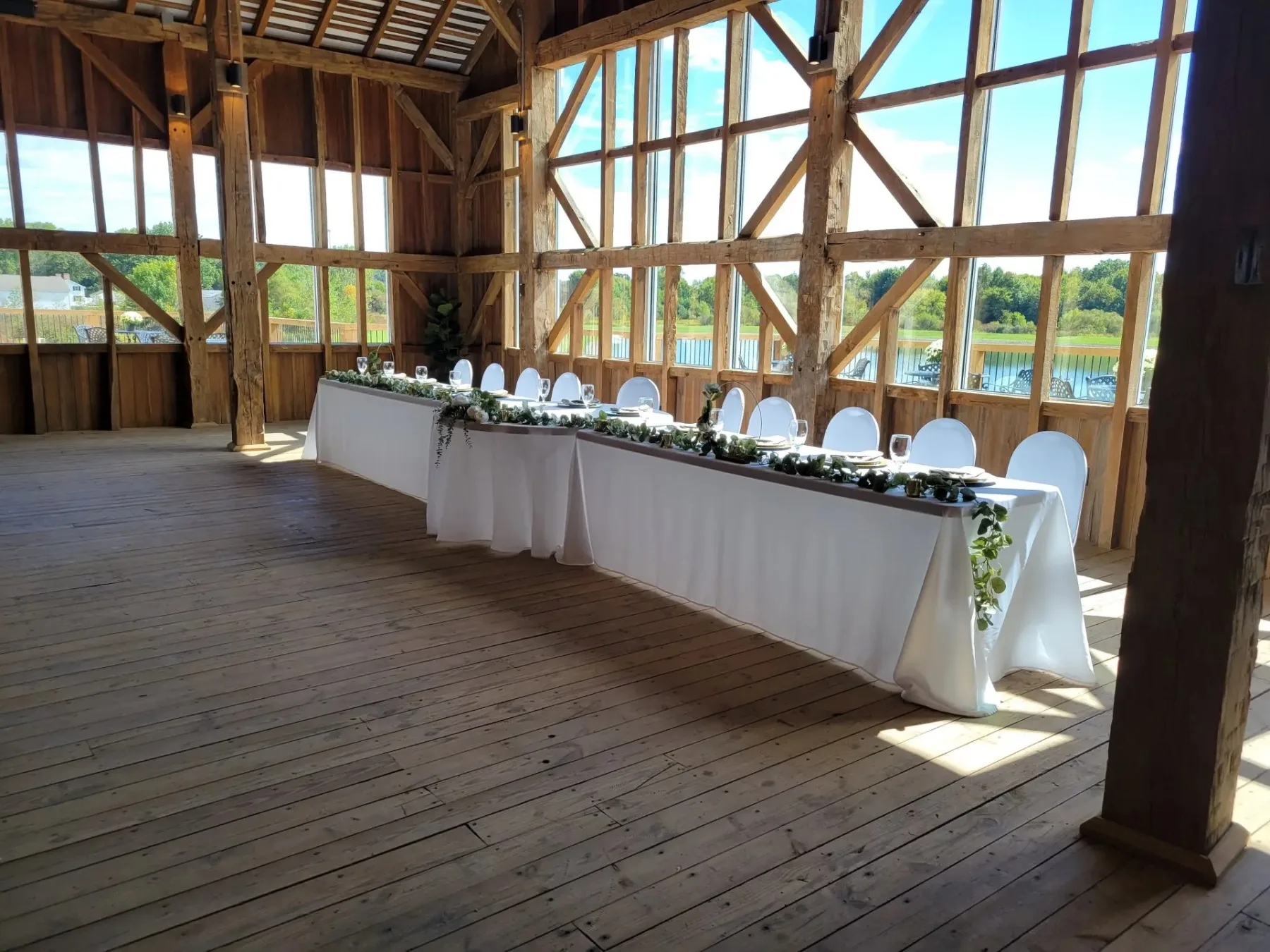 The 1880 Hall with its head table set before a soaring timber-framed window wall overlooking the lake