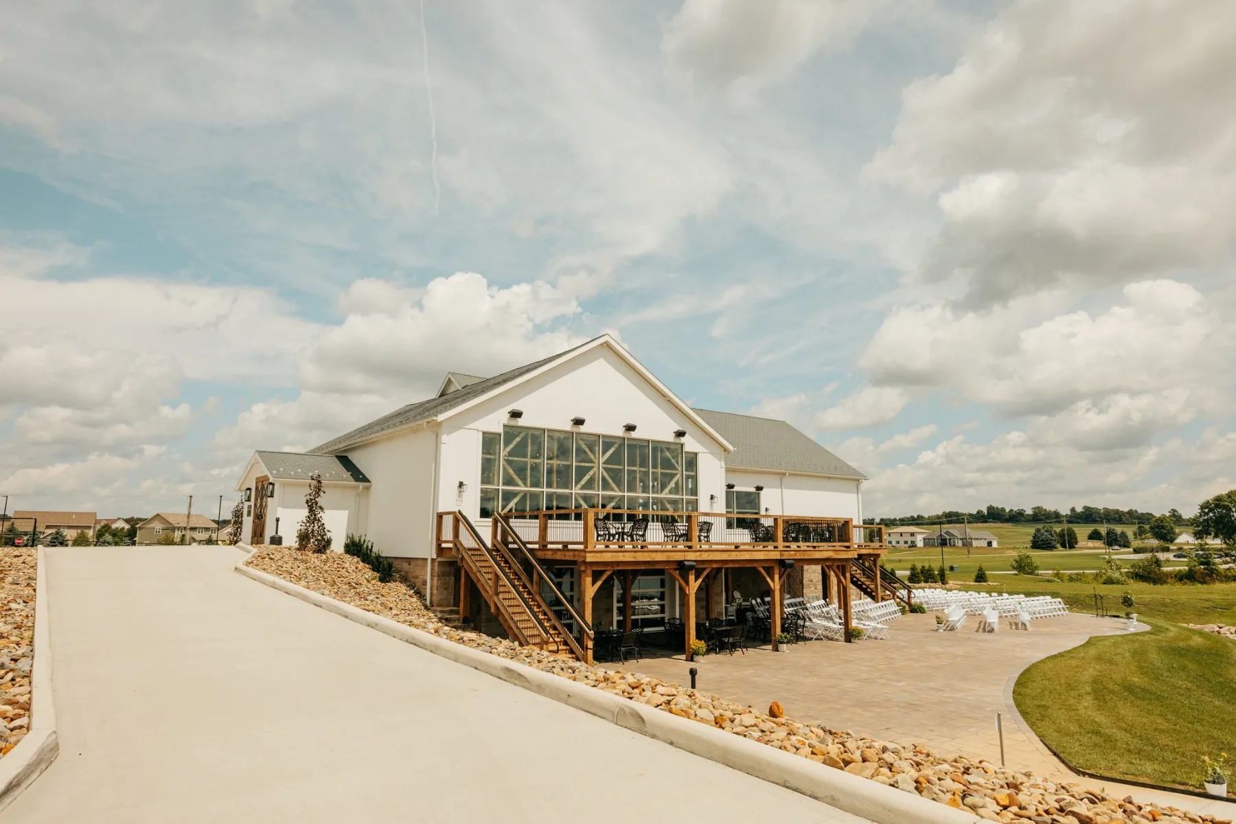 The white barn venue with its window-wall gable, deck and ceremony lawn